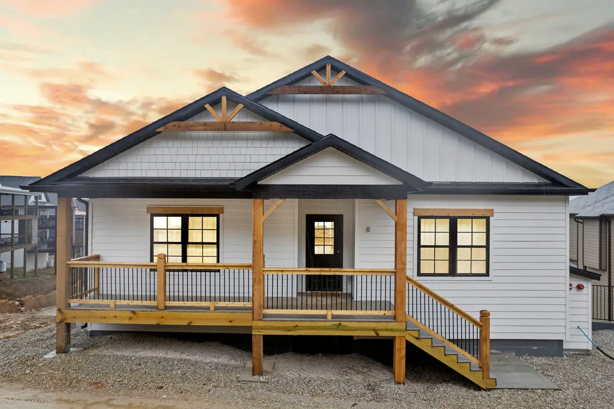 An inviting exterior shot of the home's front porch set against a colorful sunset sky. The architectural details of the house are visible, and the atmosphere is warm and welcoming, with hints of space for relaxation and family gatherings outdoors.